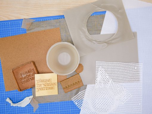 auf einer blauen Schneidematte liegen verschiedene thermoplastische Materialien: Worbla, Thibra, Varaform. teilweise sind sie bereits verformt und bearbeitet.