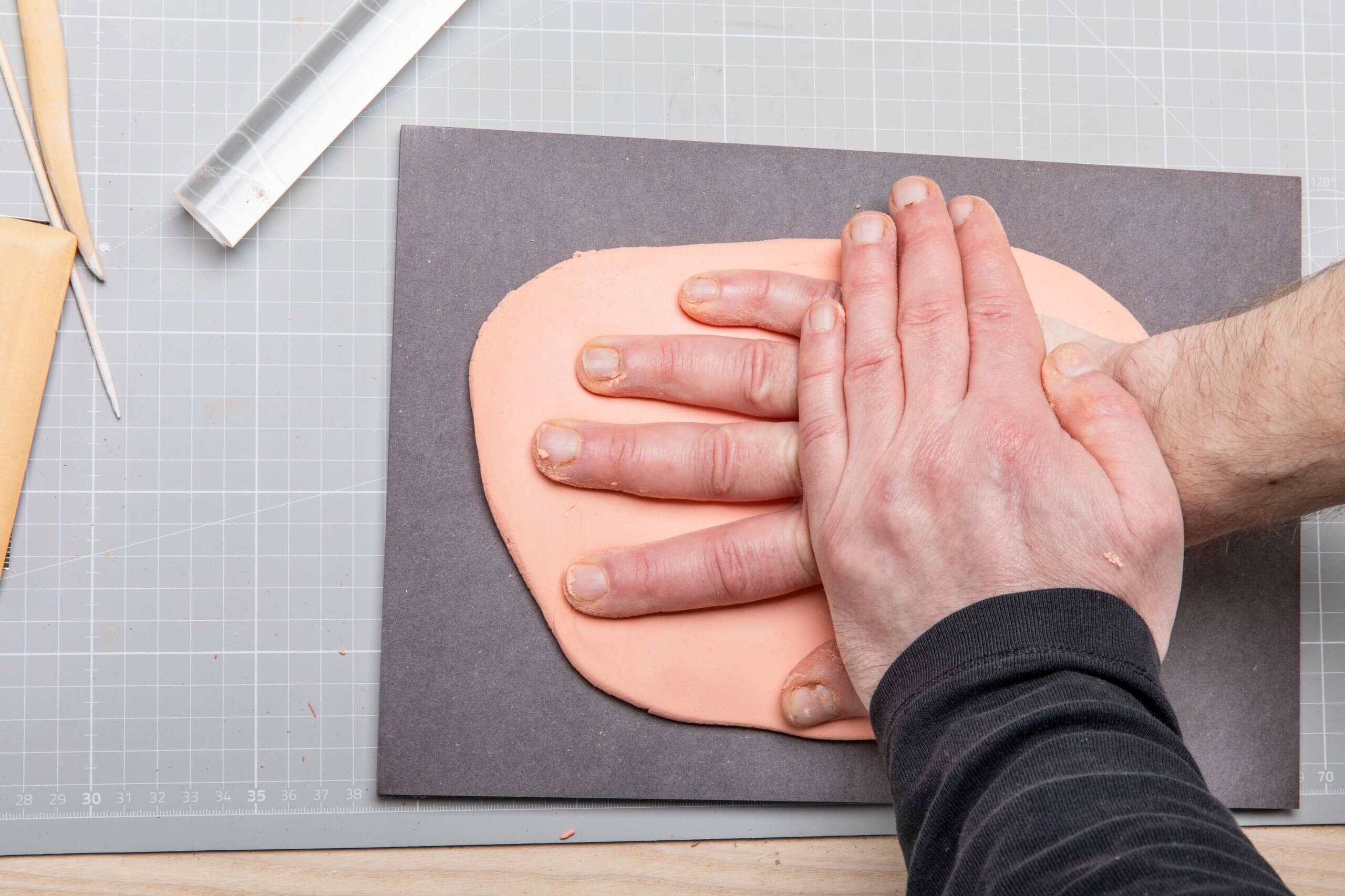 Hand abformen In flach ausgerollte Abformmasse wird eine Hand gedrückt.