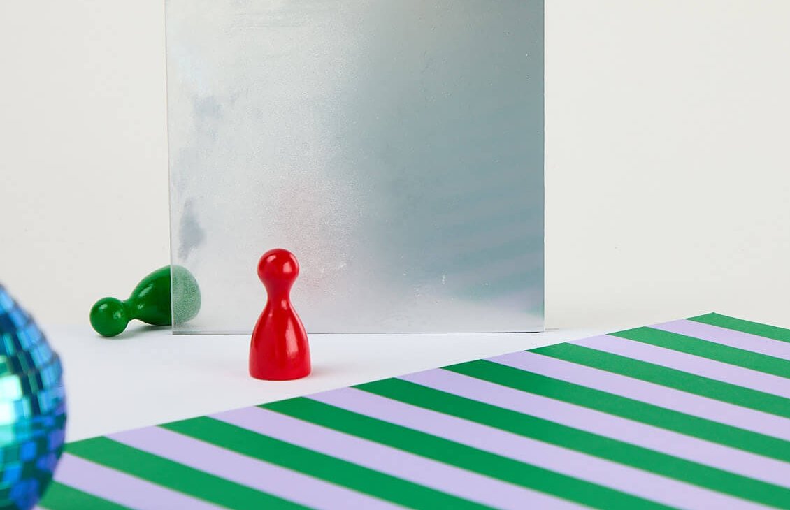 Auf eine leicht geneigt stehende Styroporplatte wird Sprühkleber (3M Photo Mount) aufgesprüht.